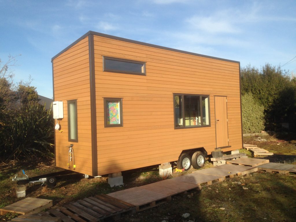 The tiny house in its current glory. Clad fully in Cedar with solid custom cedar door. Note the califont on the end.